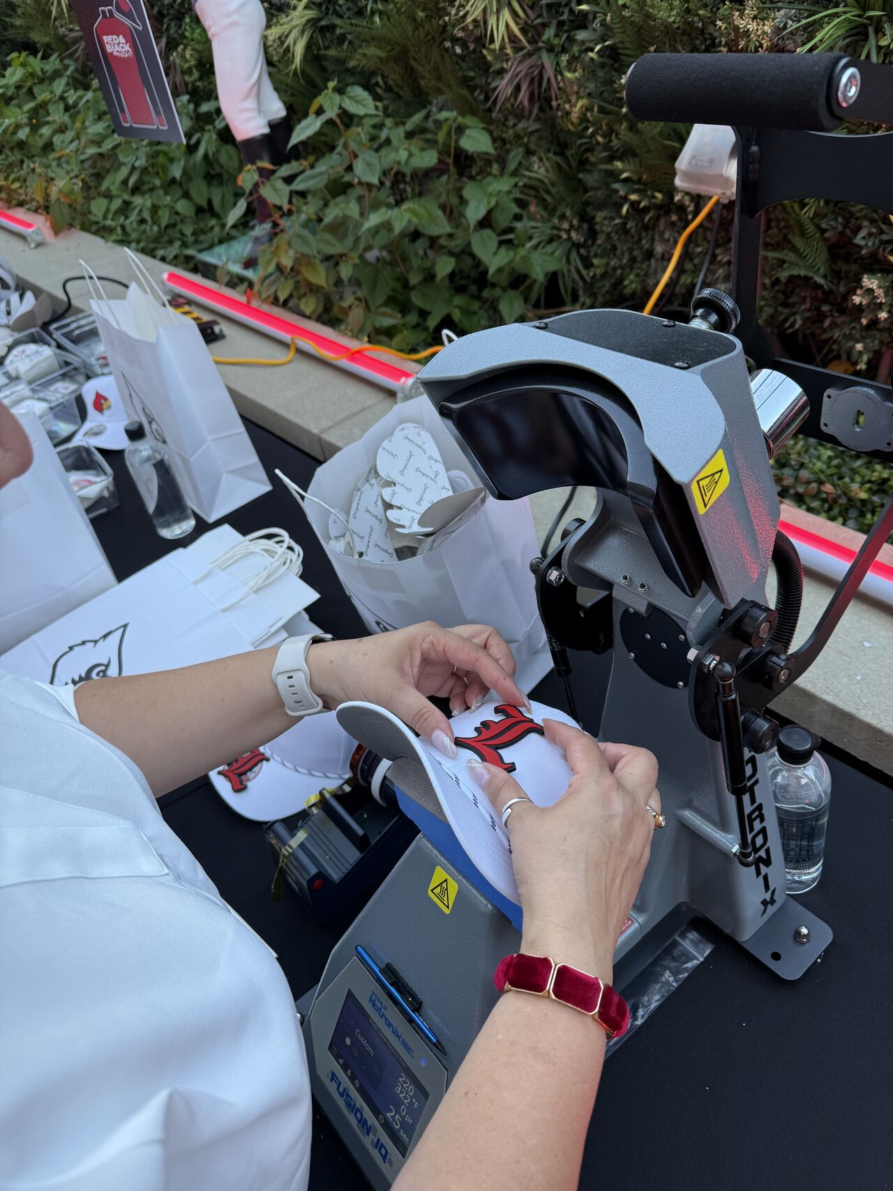 Live heat pressing a custom Louisville cap on location at an event